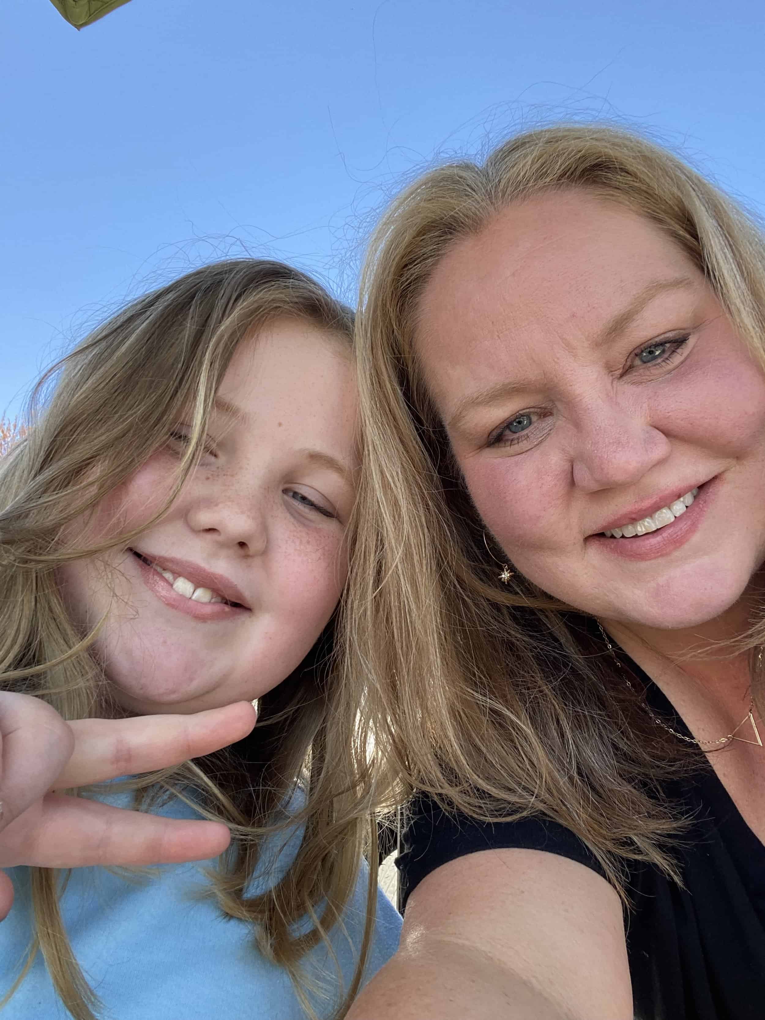 Chef Sara Barnes, smiling, in a selfie outdoors with a young companion